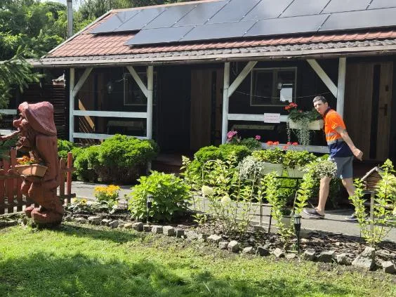 Cottage facade with solar panels and flower beds