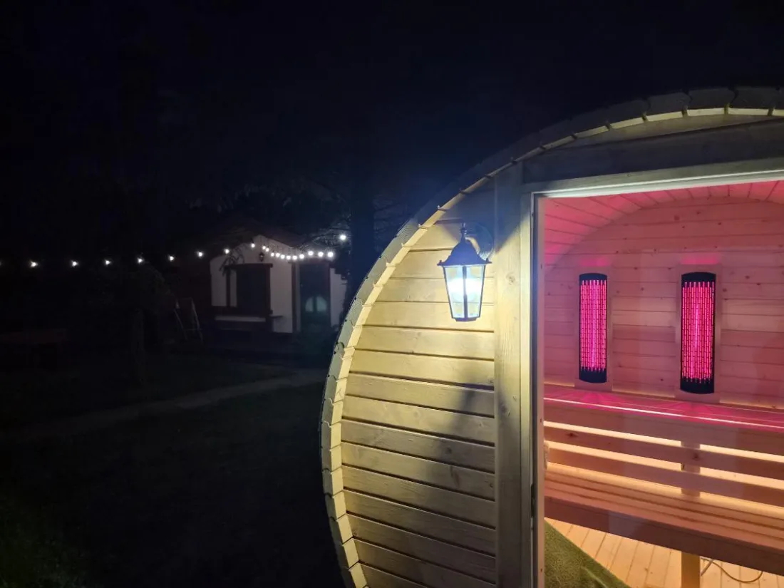 Barrel sauna in the garden in the evening